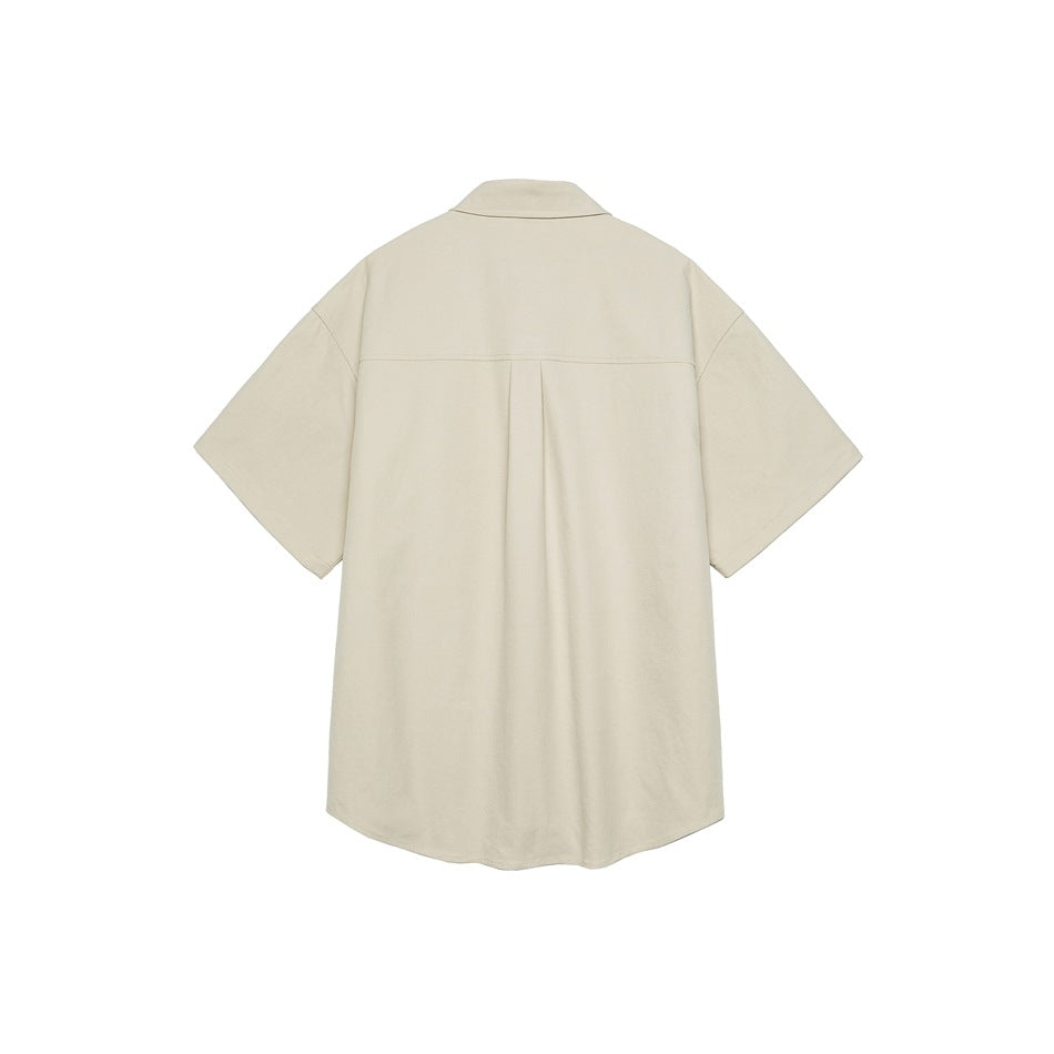 Back view of a beige-gray short-sleeve shirt showing the back yoke seam, center pleat and curved hem