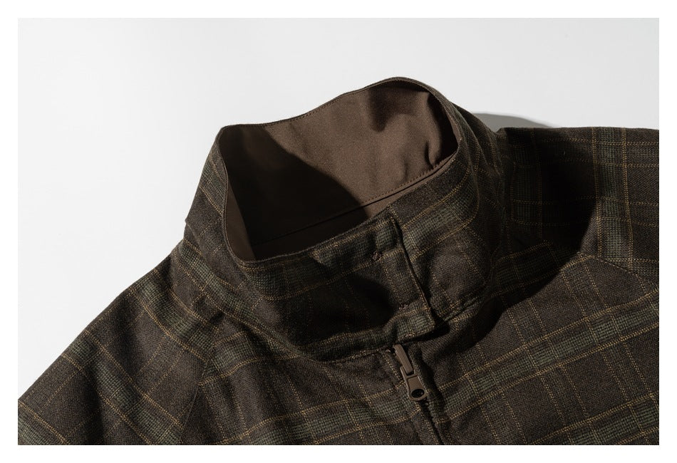 Close-up of a brown plaid jacket's stand collar and front zipper.