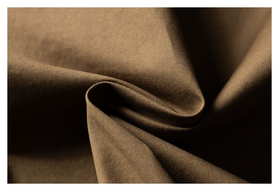 Close-up of brown fabric draped into soft folds, showing its fine diagonal weave.