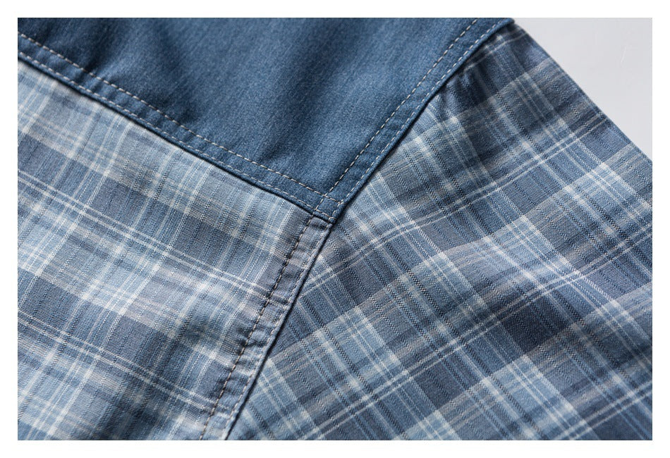 Close-up of a curved seam joining blue denim and blue-gray plaid fabric.