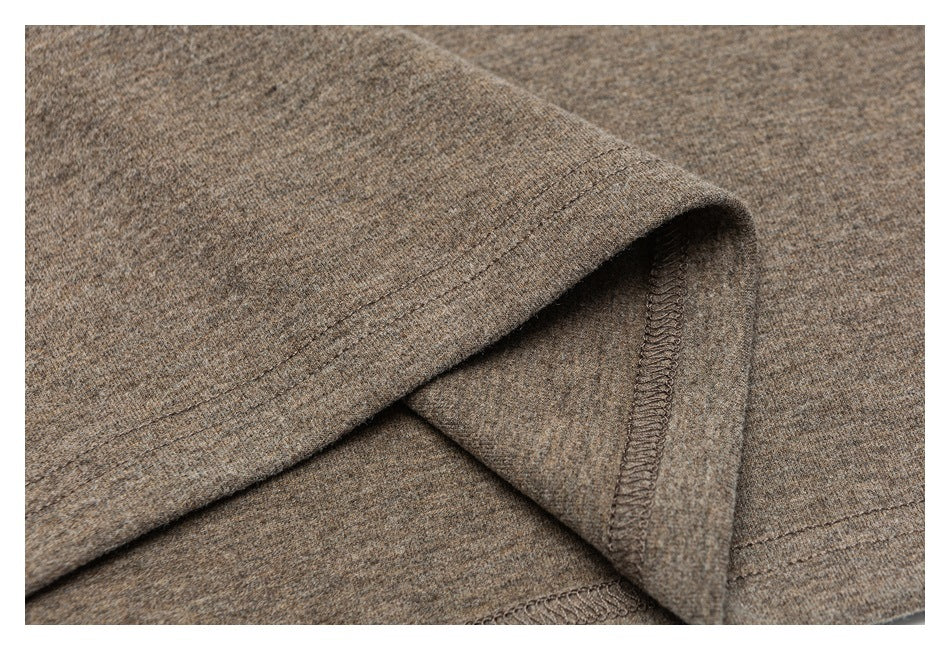 Close-up of the taupe-brown garment hem, showing stitching and an overlocked inner seam.