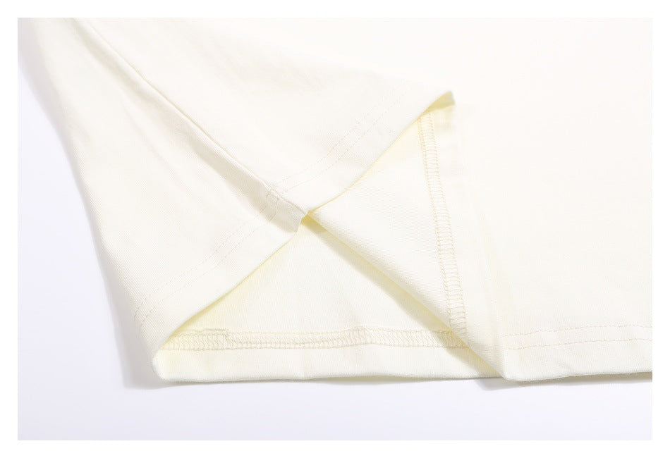 Close-up of an off-white T-shirt seam and stitching where the sleeve meets the body.