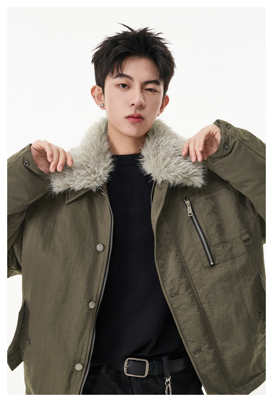Close view of a model wearing the olive jacket open, showing its plush collar, zip pocket and snap details.