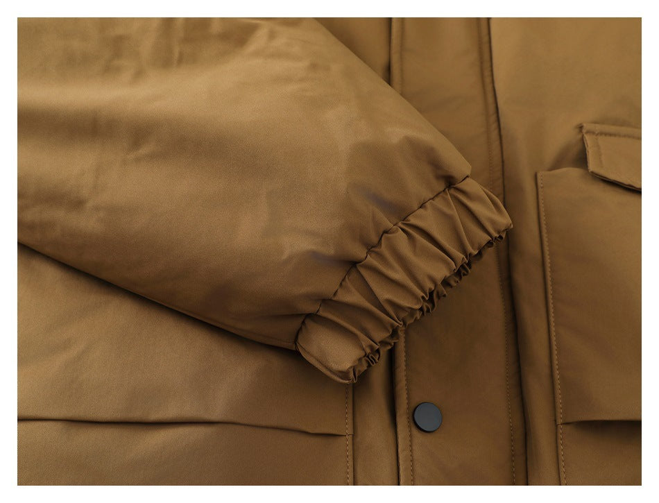 Close-up of the tan jacket's gathered elastic sleeve cuff and snap-button placket.