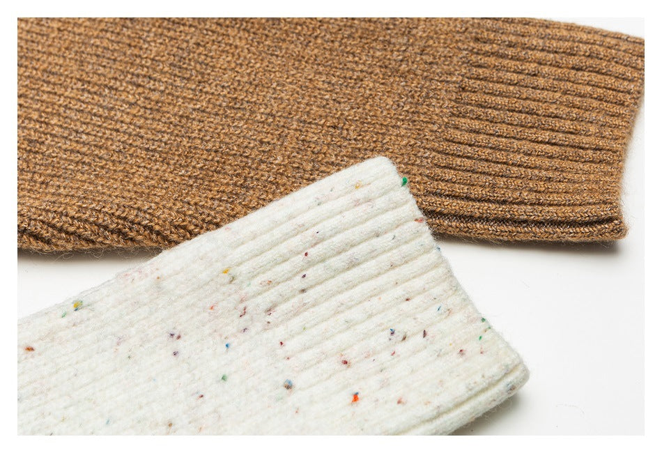 Close-up of ribbed sweater cuffs in brown and ivory speckled knit.