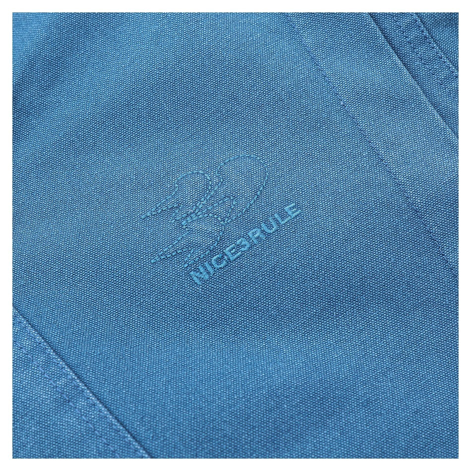 Close-up of blue woven fabric with a small tonal embroidered heart and lettering.
