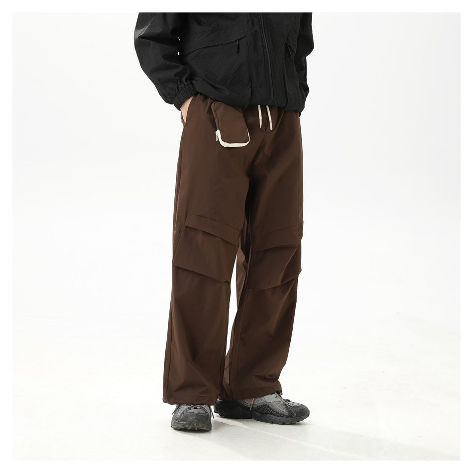 Model wearing loose dark brown cargo pants with layered thigh pockets and a white-trimmed waist pocket.