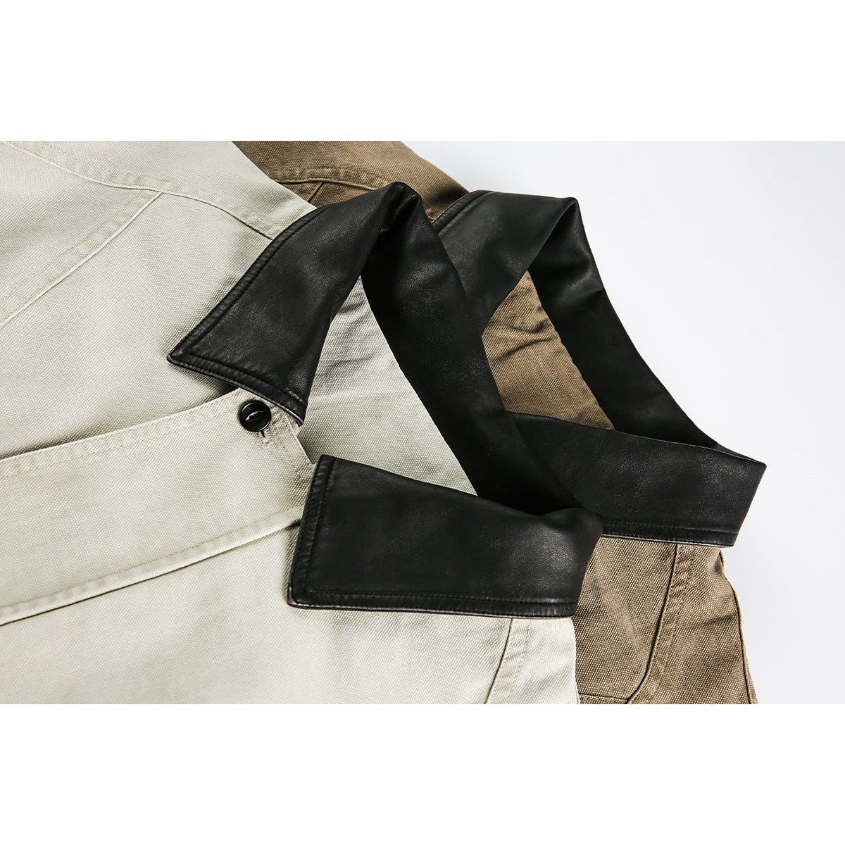 Close-up of a light beige jacket with a black collar and a black button.
