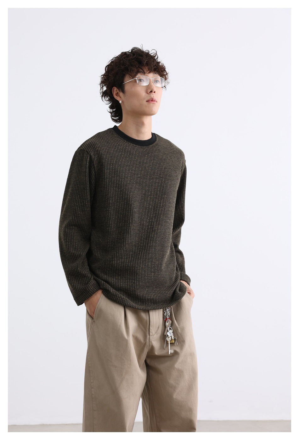 Model wearing a dark brown subtly striped long-sleeve shirt with a black crew neck, shown from a slight angle.