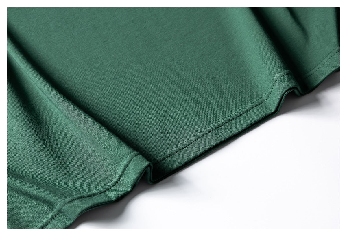 Close-up of the dark green T-shirt's lower hem and stitching.