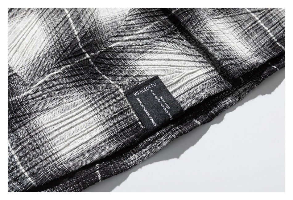 Close-up of a black-and-white plaid garment with a small sewn-in black label.