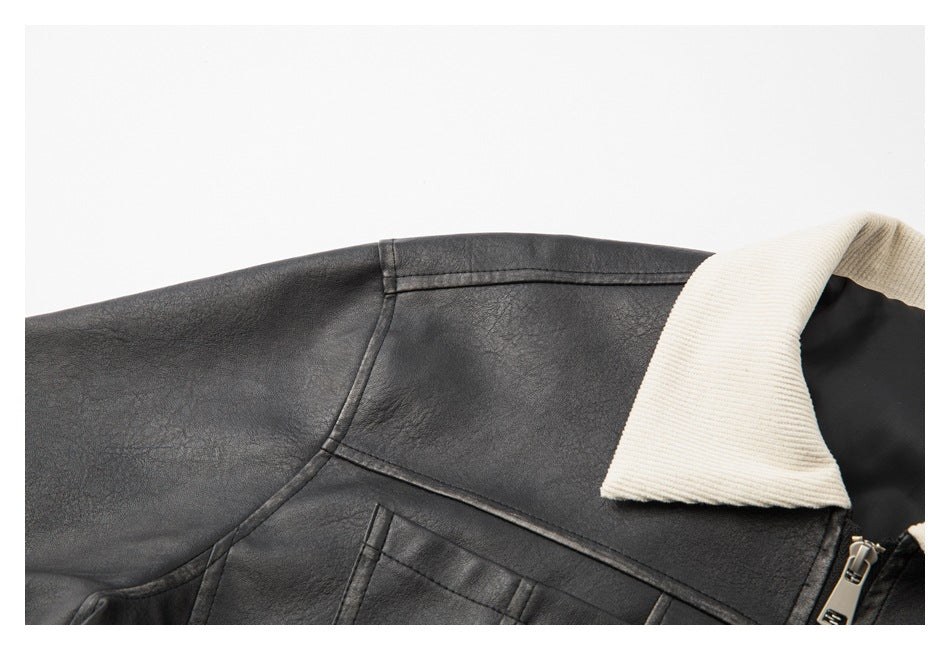 Close-up of the black jacket's shoulder seam, cream ribbed collar, and upper chest pocket.