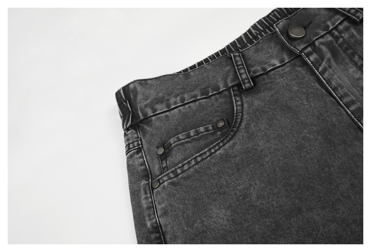 Close-up of a front pocket with metal rivets and belt loop on charcoal-gray jeans.