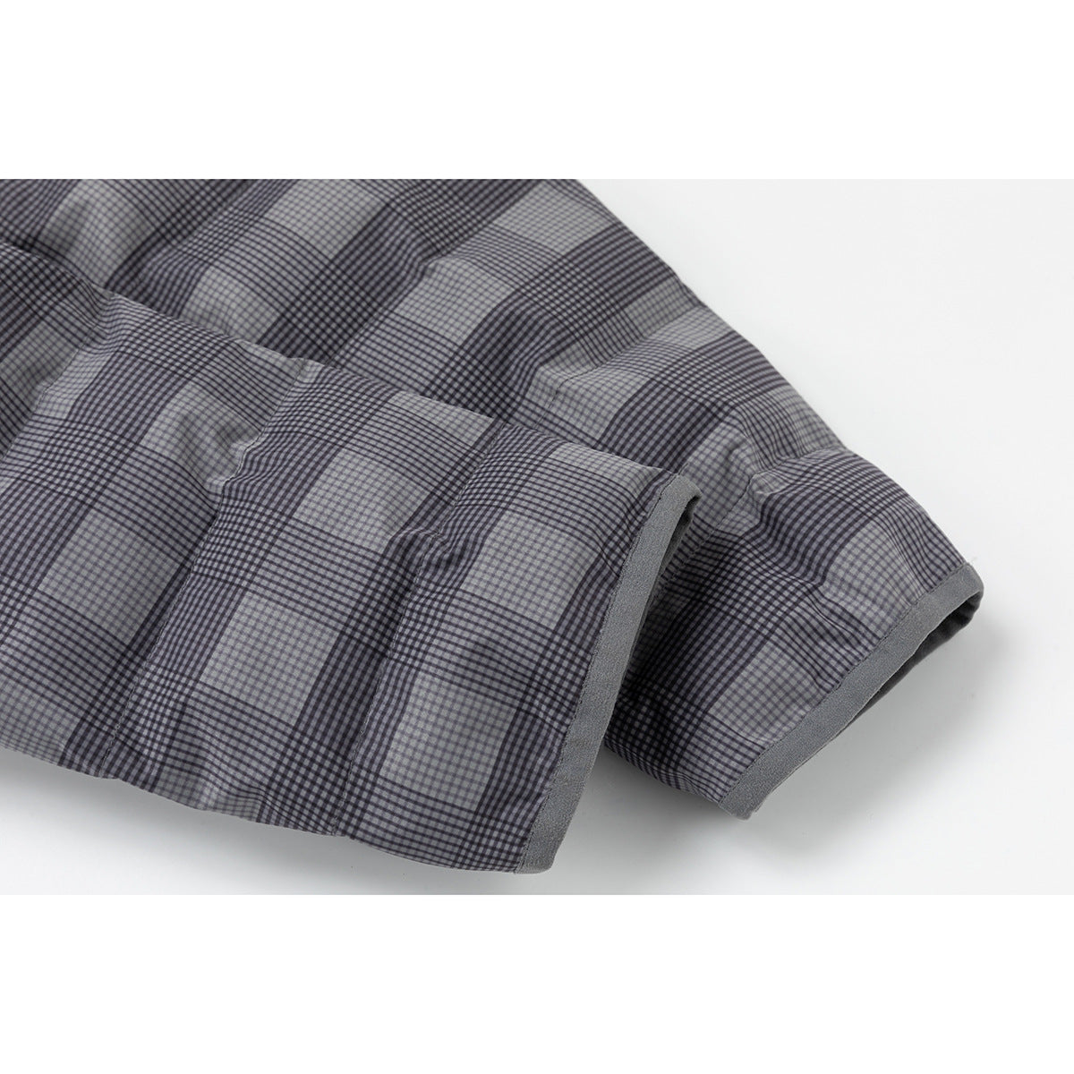 Close-up of gray-and-black plaid jacket sleeves with plain gray binding at the cuffs.