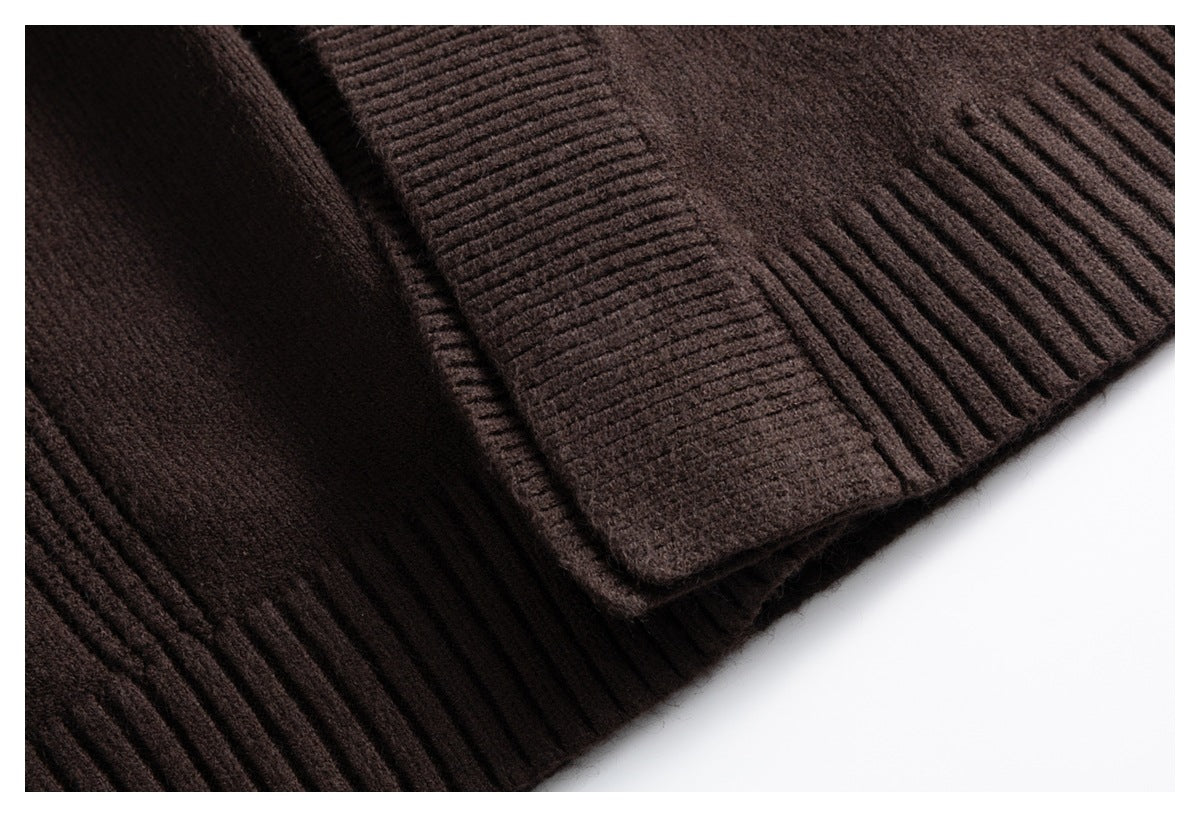 Close-up of the dark brown knit garment's ribbed hem and overlapping fabric edge.