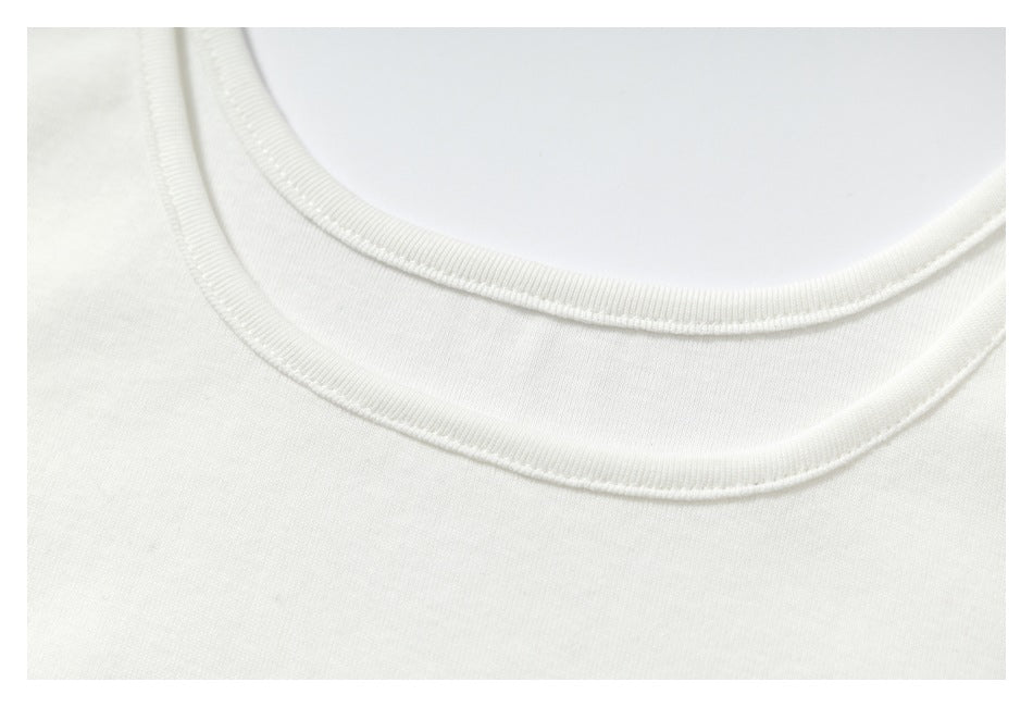 Close-up of the white sleeveless top's rounded neckline and stitched trim.