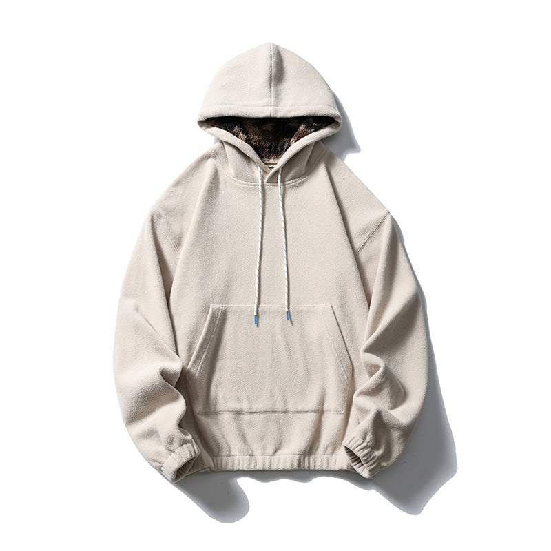 Sand beige fleece-like pullover hoodie with front pocket, white drawcords and patterned plush hood lining, flat lay