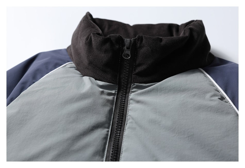 Close-up of a gray and navy jacket with a black stand collar and front zipper.