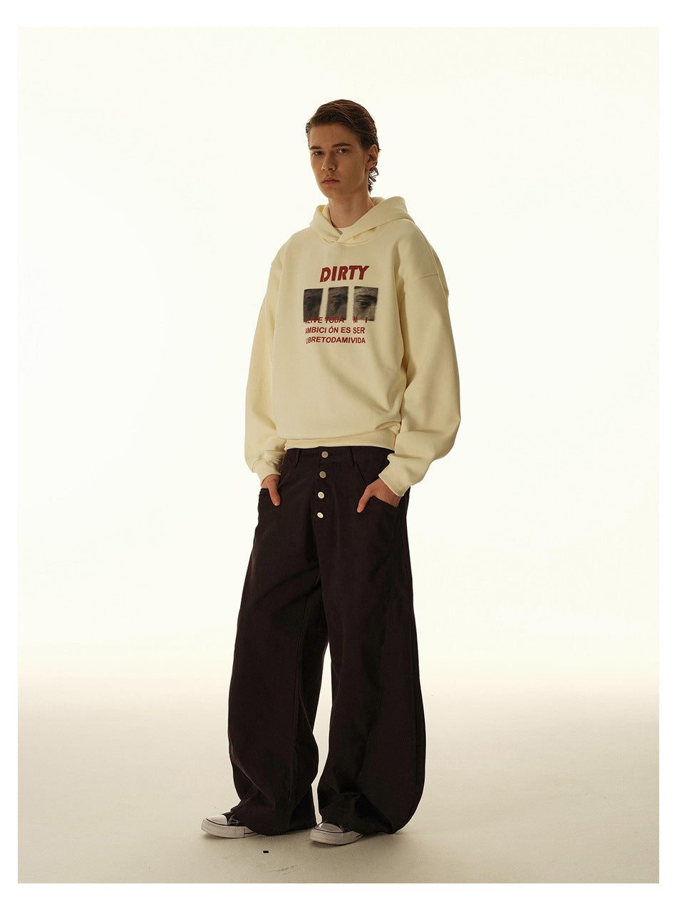 Full-length model wearing a cream graphic hoodie and extremely wide black button-front trousers.