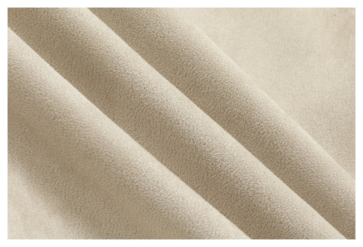 Macro view of the textured cream fabric, draped in soft folds.