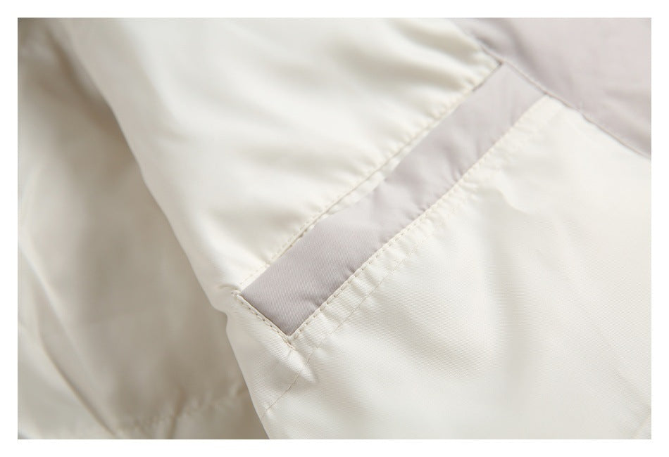 Close-up of an ivory garment seam with a pale taupe inset panel.