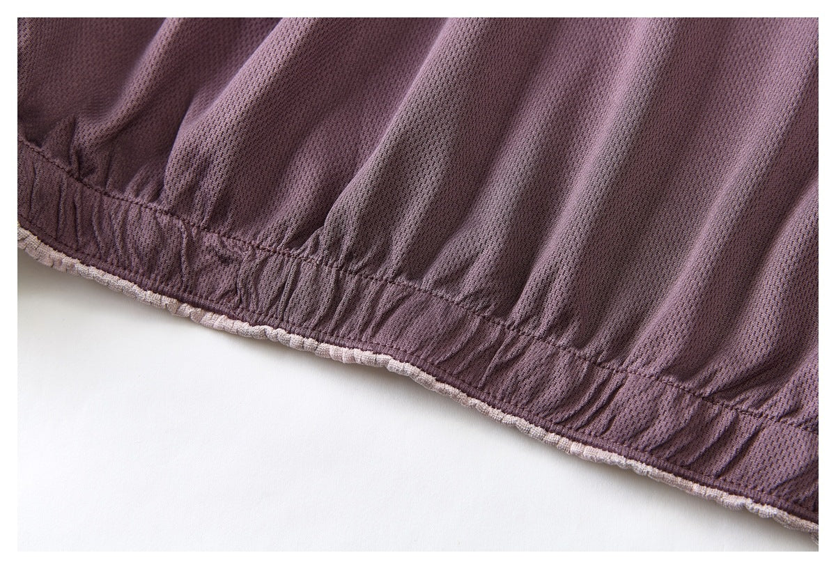 Close-up of mauve textured fabric with a gathered, stitched edge.
