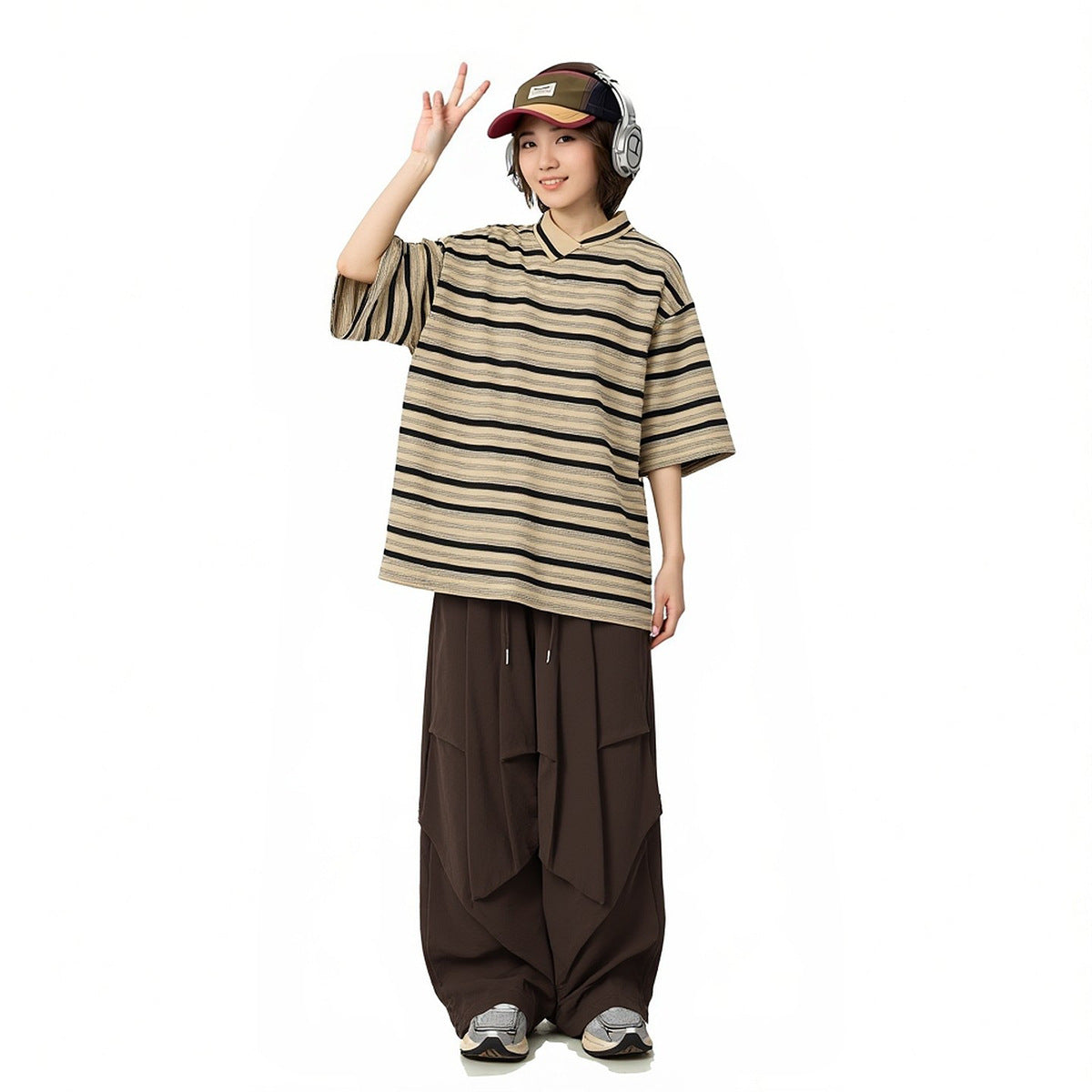 Model wearing a loose beige-and-black striped V-neck shirt with wide dark brown draped trousers.