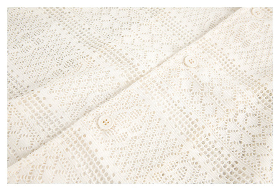 Close-up of two cream buttons on the front placket of an ivory lace shirt.