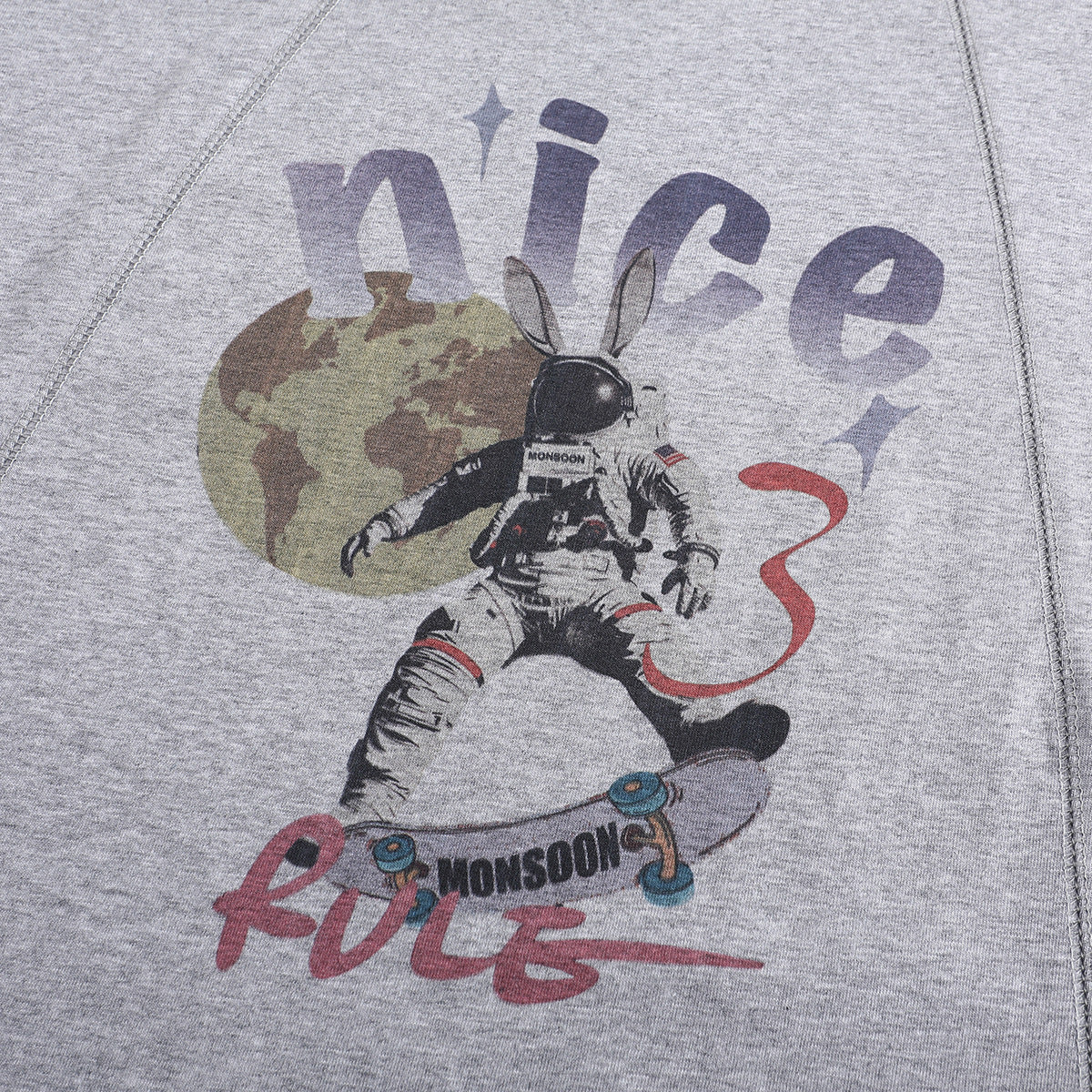 Close-up of a heather-gray T-shirt graphic showing an astronaut rabbit, a globe, and stylized lettering.