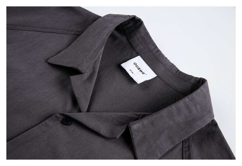 Close-up of the charcoal shirt’s collar, stitching, and sewn-in neck label.