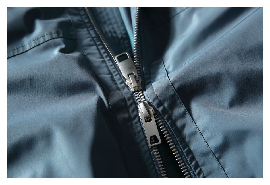 Close-up of the jacket's silver two-way front zipper and surrounding blue fabric.