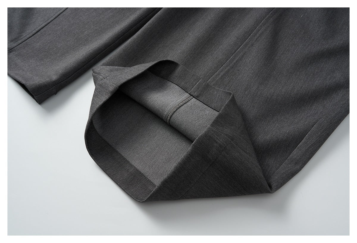 Close-up of a charcoal trouser hem folded back to show the inside stitching and finish.
