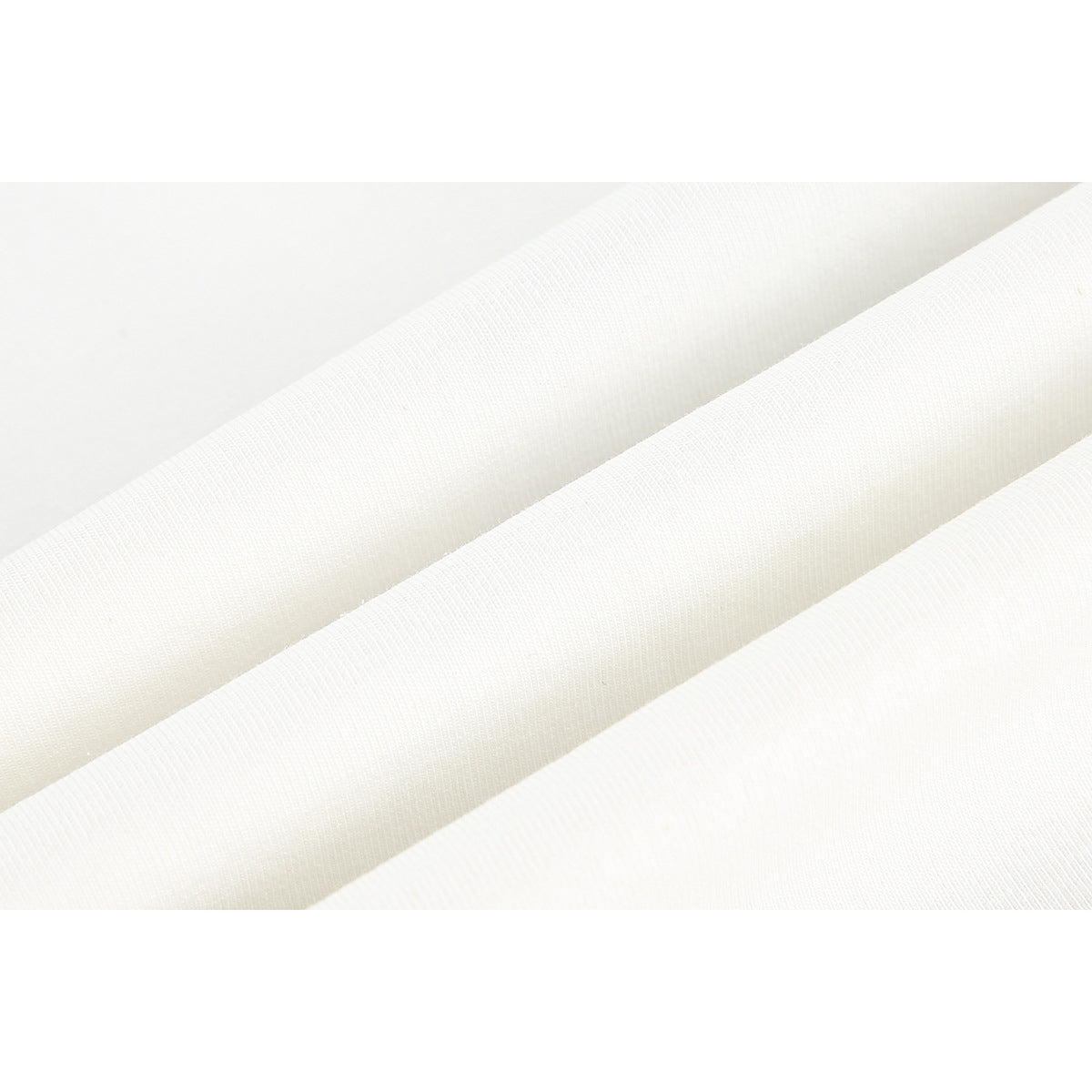 Close-up of cream-colored fabric arranged in soft folds, showing its surface texture.