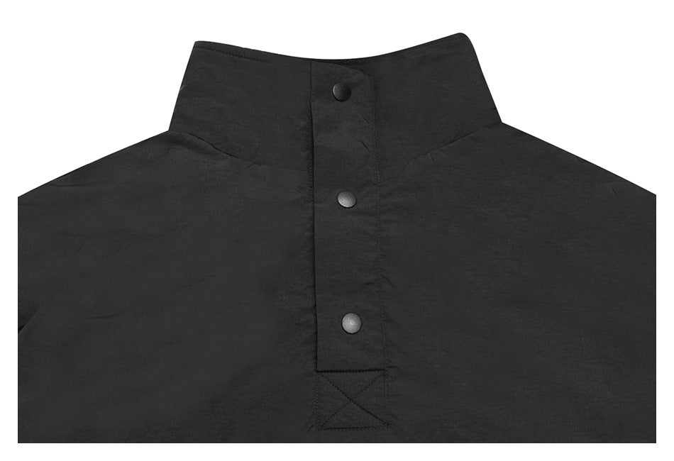 Close-up of the black garment's upper front, with a stand collar and three-snap placket.