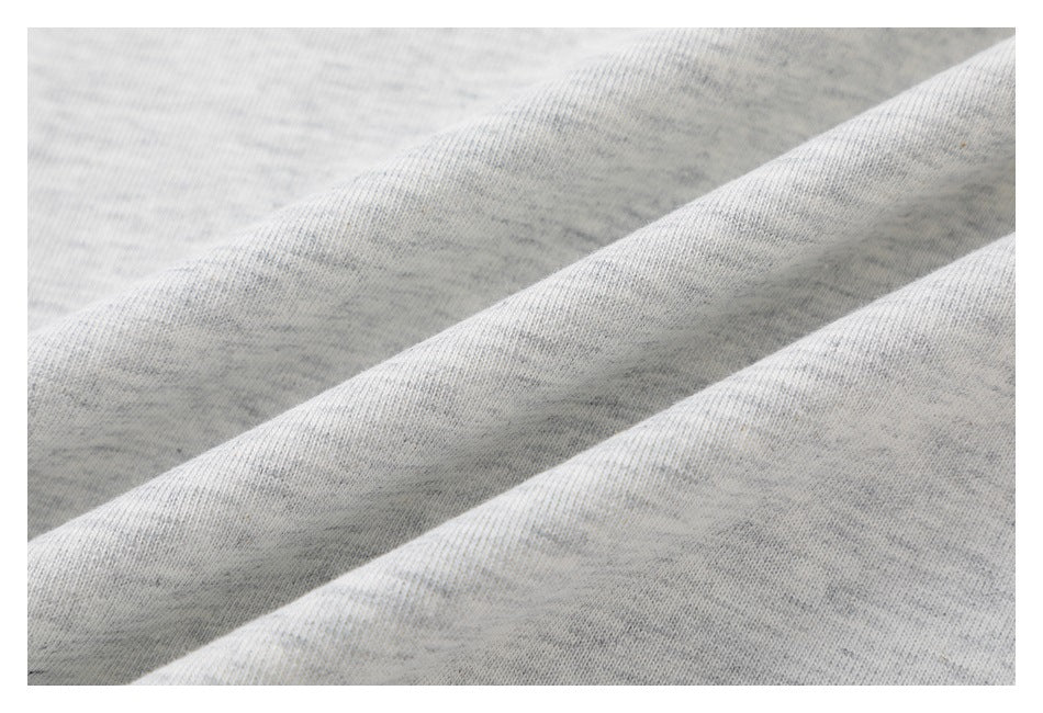 Close-up of the textured light gray heather T-shirt fabric draped in soft folds.