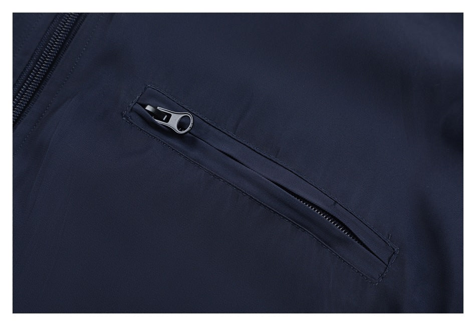 Close-up of a navy jacket showing a diagonal zip pocket and part of the main zipper.