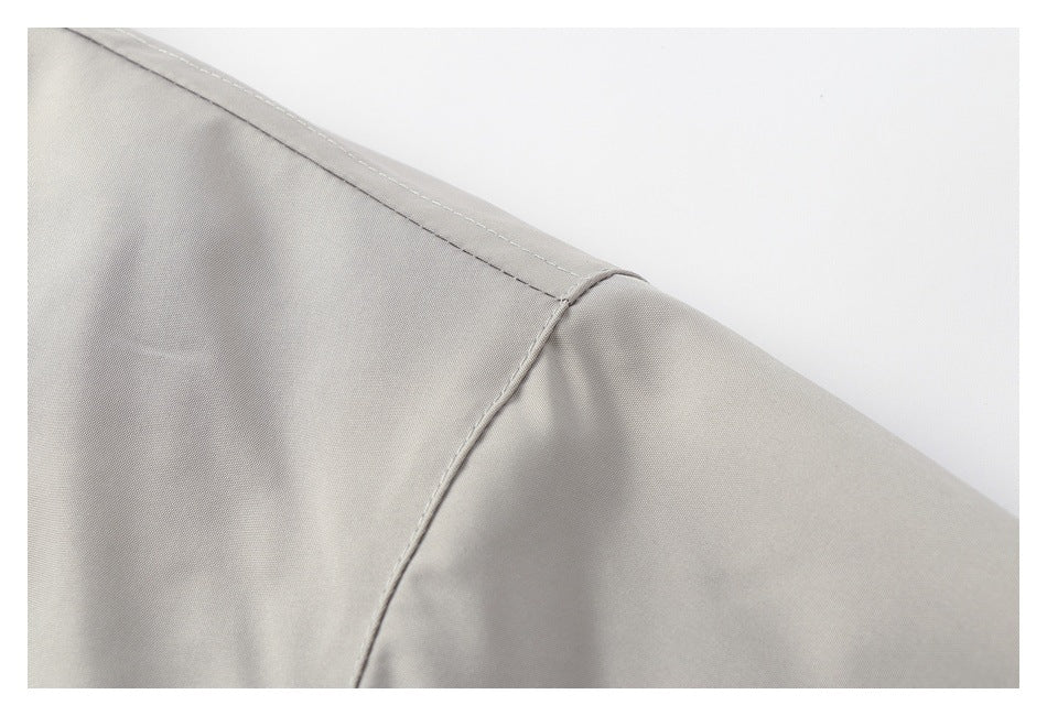 Close-up of a light gray jacket shoulder seam and stitching.