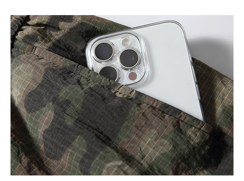 Close-up of a phone tucked into a pocket on dark plaid pants.