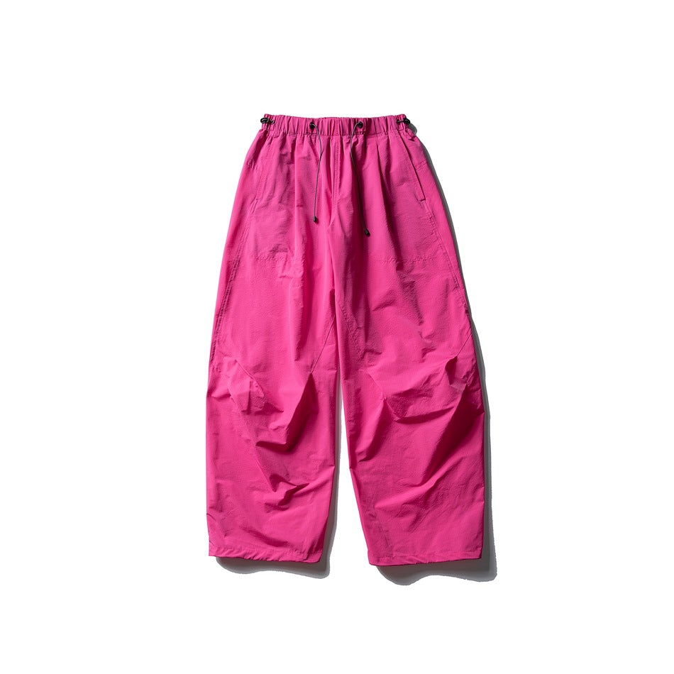 Hot pink wide-leg parachute pants with drawcord elastic waistband, flat lay front view