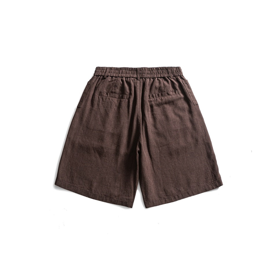 Back view of brown shorts laid flat, with a gathered waistband and two rear pockets.