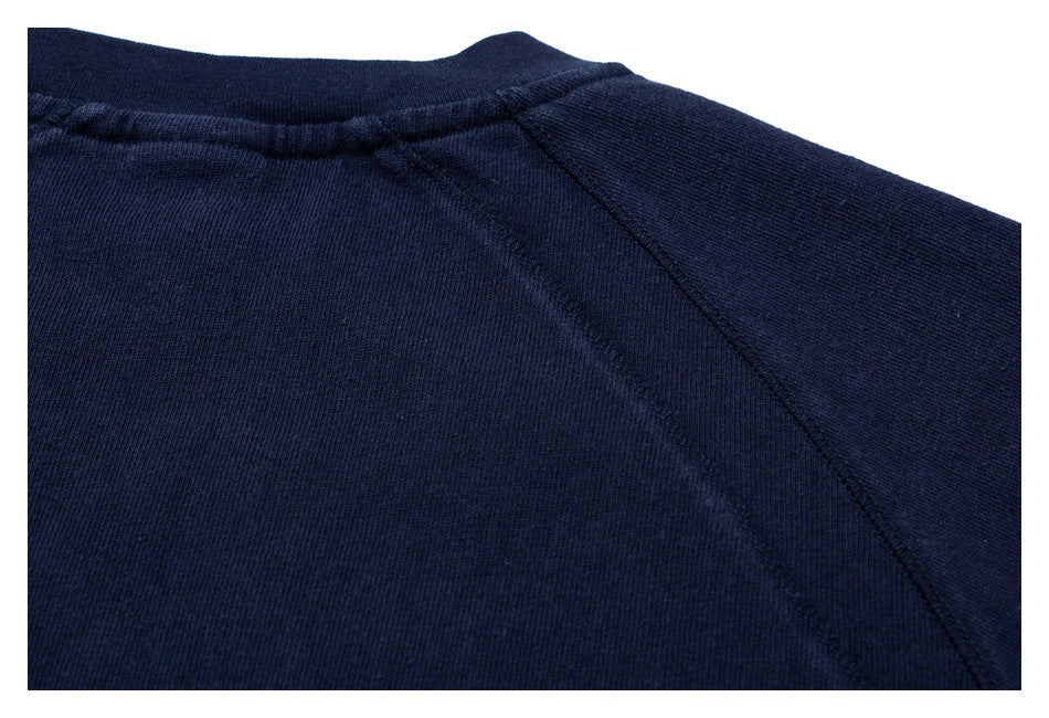 Close-up of the back neckline and raglan shoulder seam on a navy shirt.