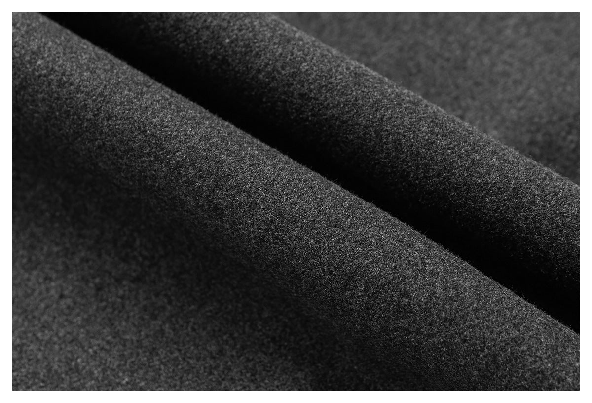 Extreme close-up of dark charcoal textured fabric folded into soft diagonal ridges.