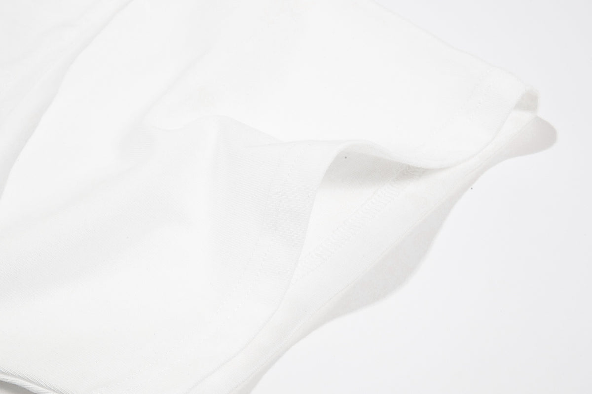 Close-up of white T-shirt fabric and a folded stitched sleeve or hem edge.