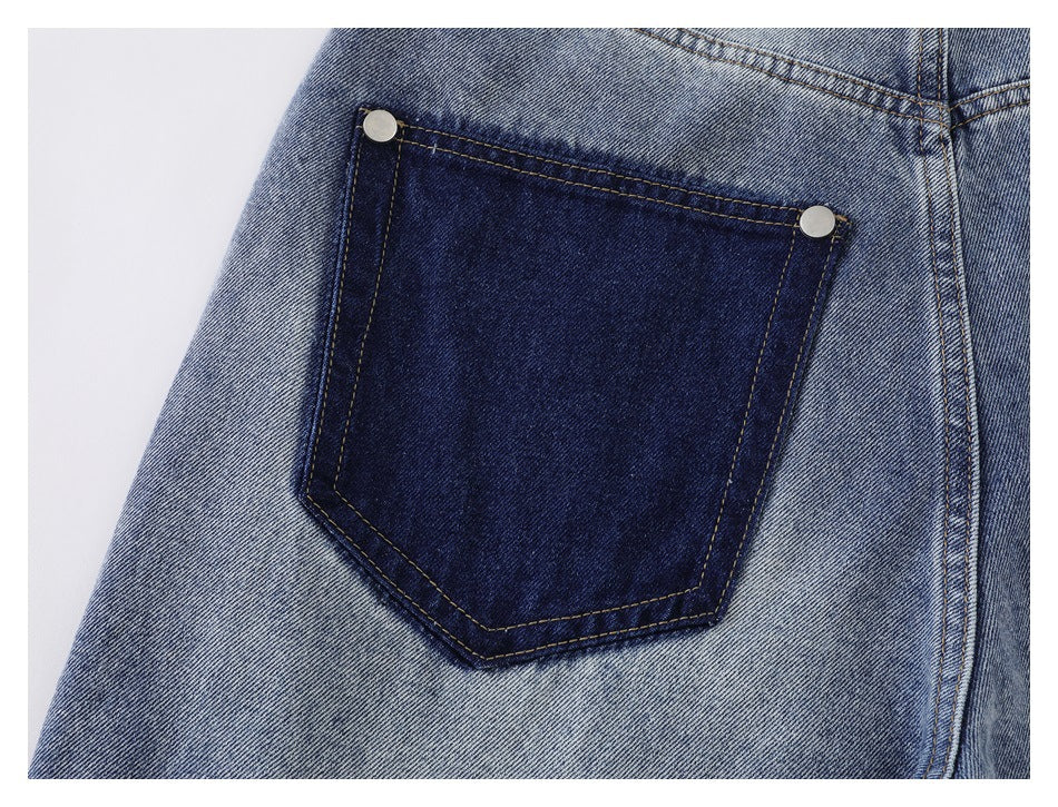 Close-up of a dark indigo back pocket with tan stitching and two metal rivets on faded blue jeans.