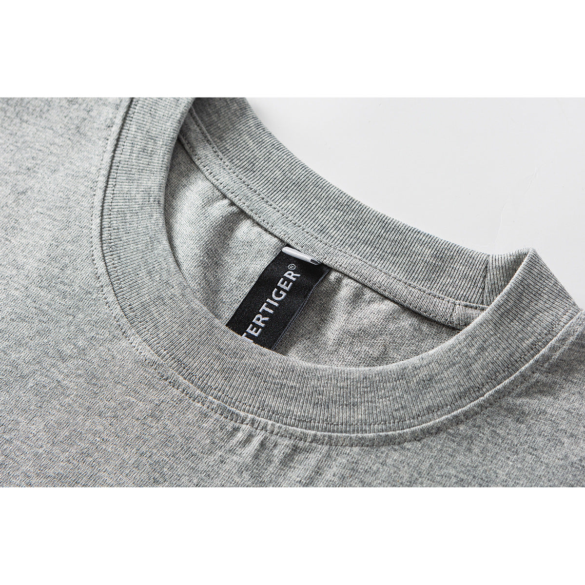 Close-up of a gray heather T-shirt's ribbed crew neck and black woven neck label.