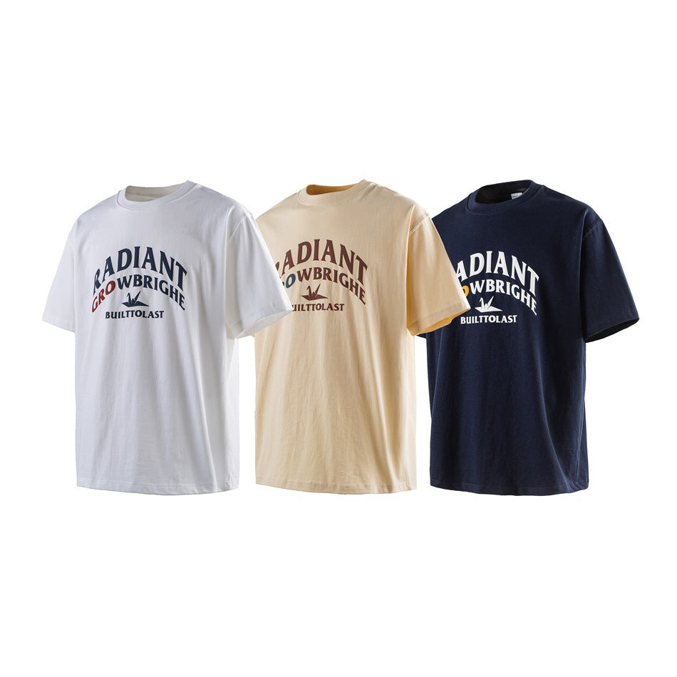 Three short-sleeve graphic T-shirts shown from the front in white, cream, and navy.