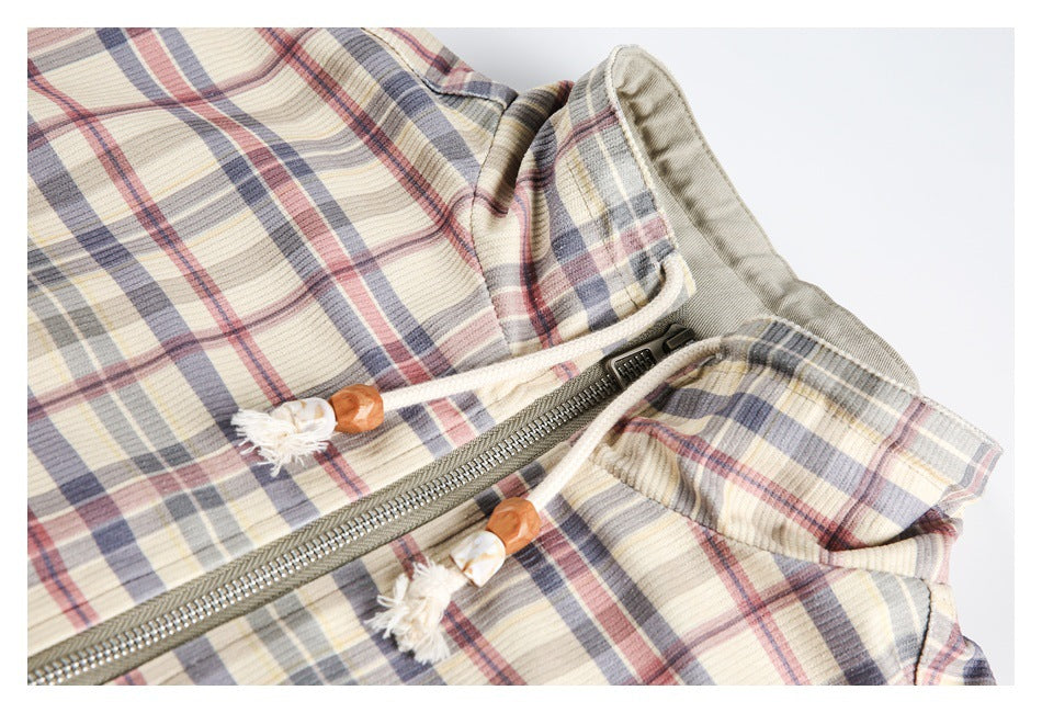 Close-up of the pastel plaid jacket's gray zipper, contrasting panels, and decorative cord pulls.