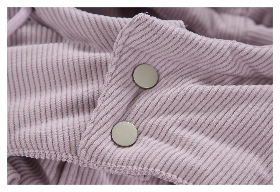 Close-up of two metal snaps on a tab of the lilac ribbed jacket.
