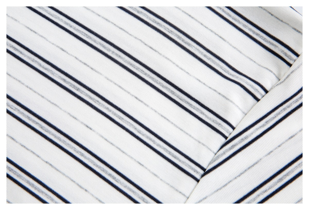 Close-up of striped white fabric showing a stitched garment seam.