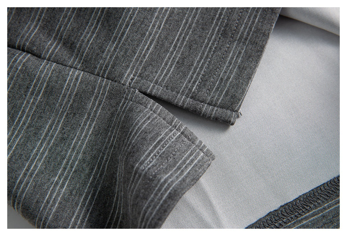 Close-up of a striped charcoal gray shirt seam and finished edge, showing the reverse side of the fabric.